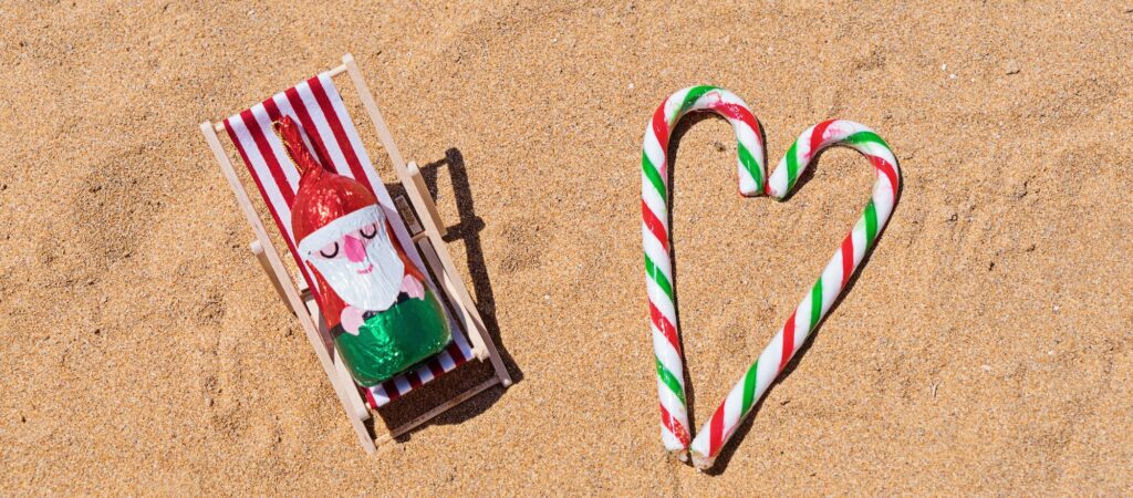 Chocolate Santa resting in lounge deck chair on sandy beach